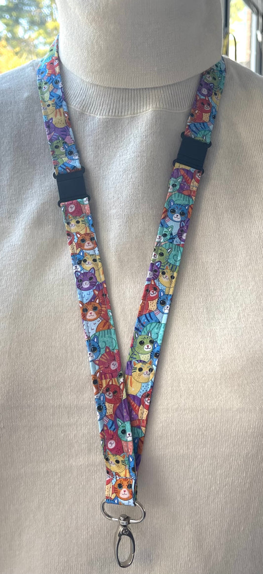 A multicolored fabric lanyard with a pattern of various cats in a breakaway design displayed on a mannequin.