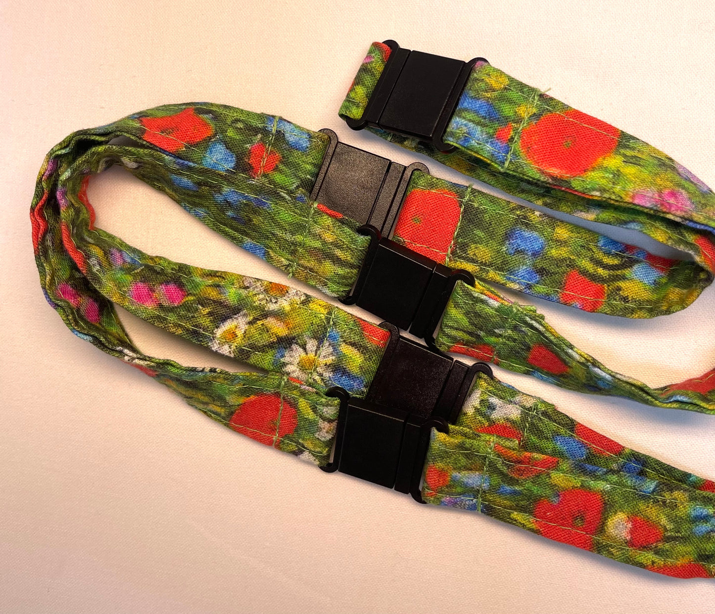 Floral-patterned lanyard with a black clip on a light background