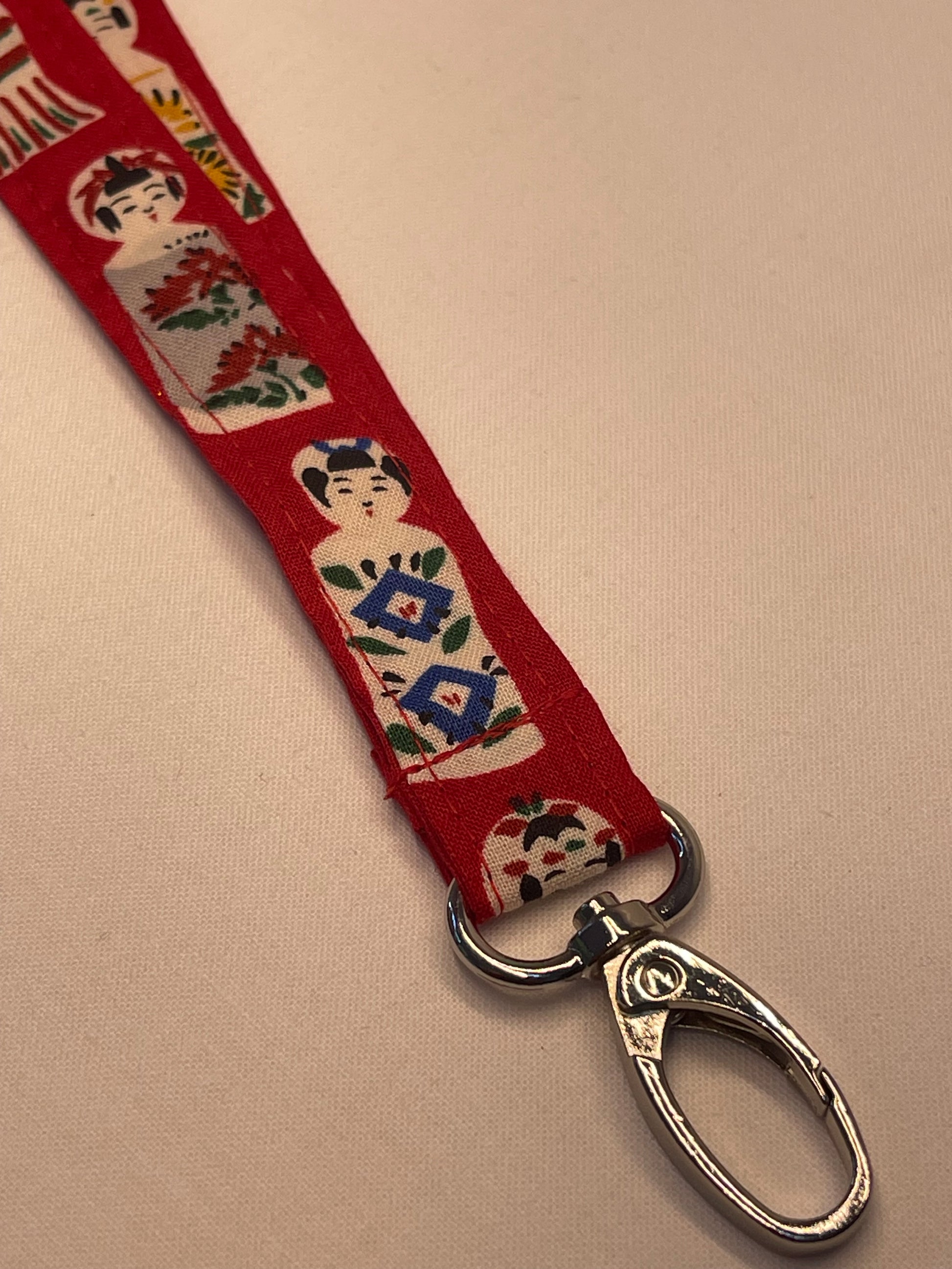 Red keychain with decorative design on a beige background