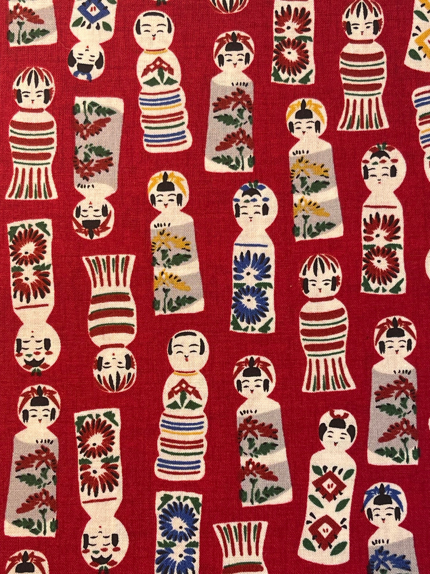 Pattern of colorful dolls on a red background