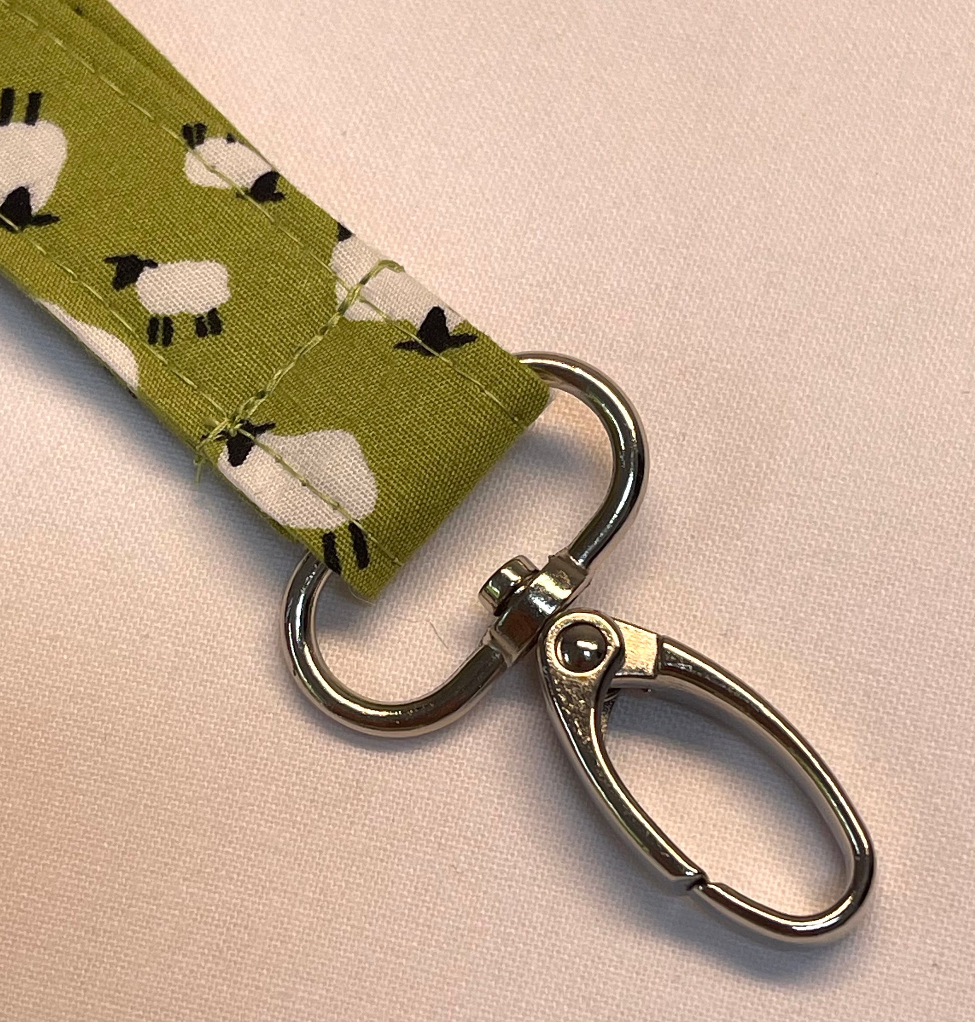 Lanyard with green fabric strap featuring sheep pattern and metal swivel clip
