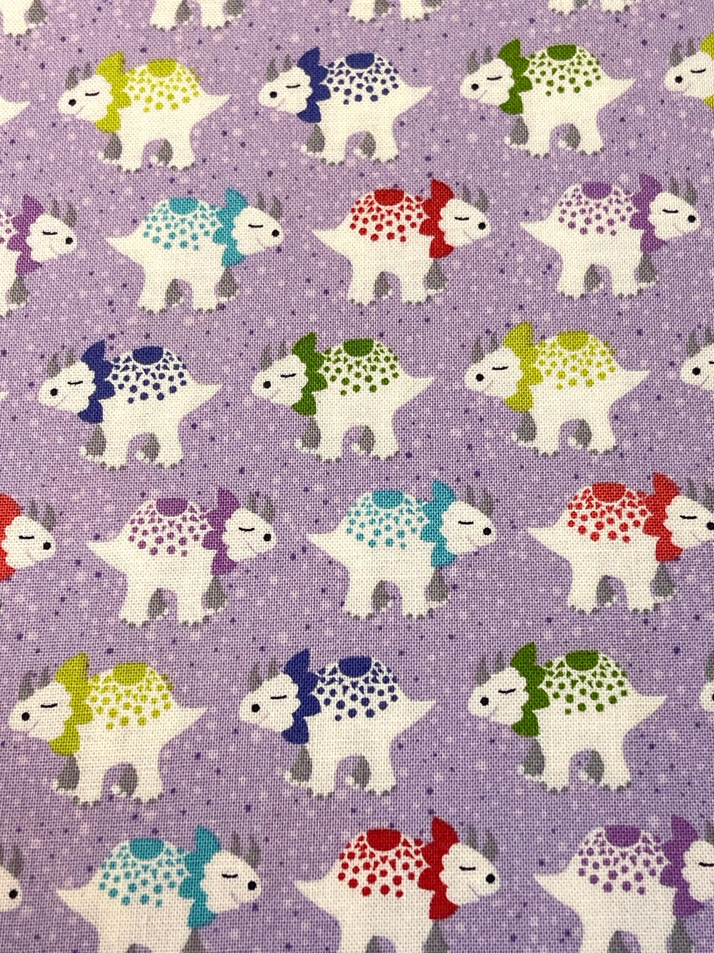 Pattern of cartoon dinosaurs on a purple background