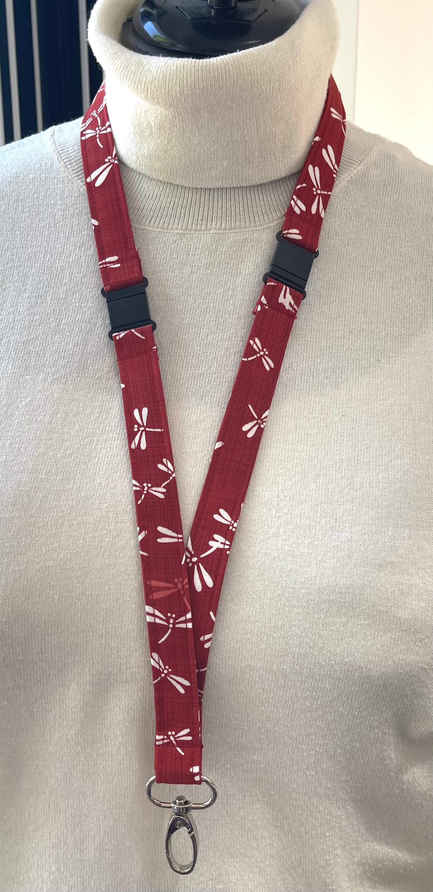 Red lanyard with white patterns on a mannequin against a light background
