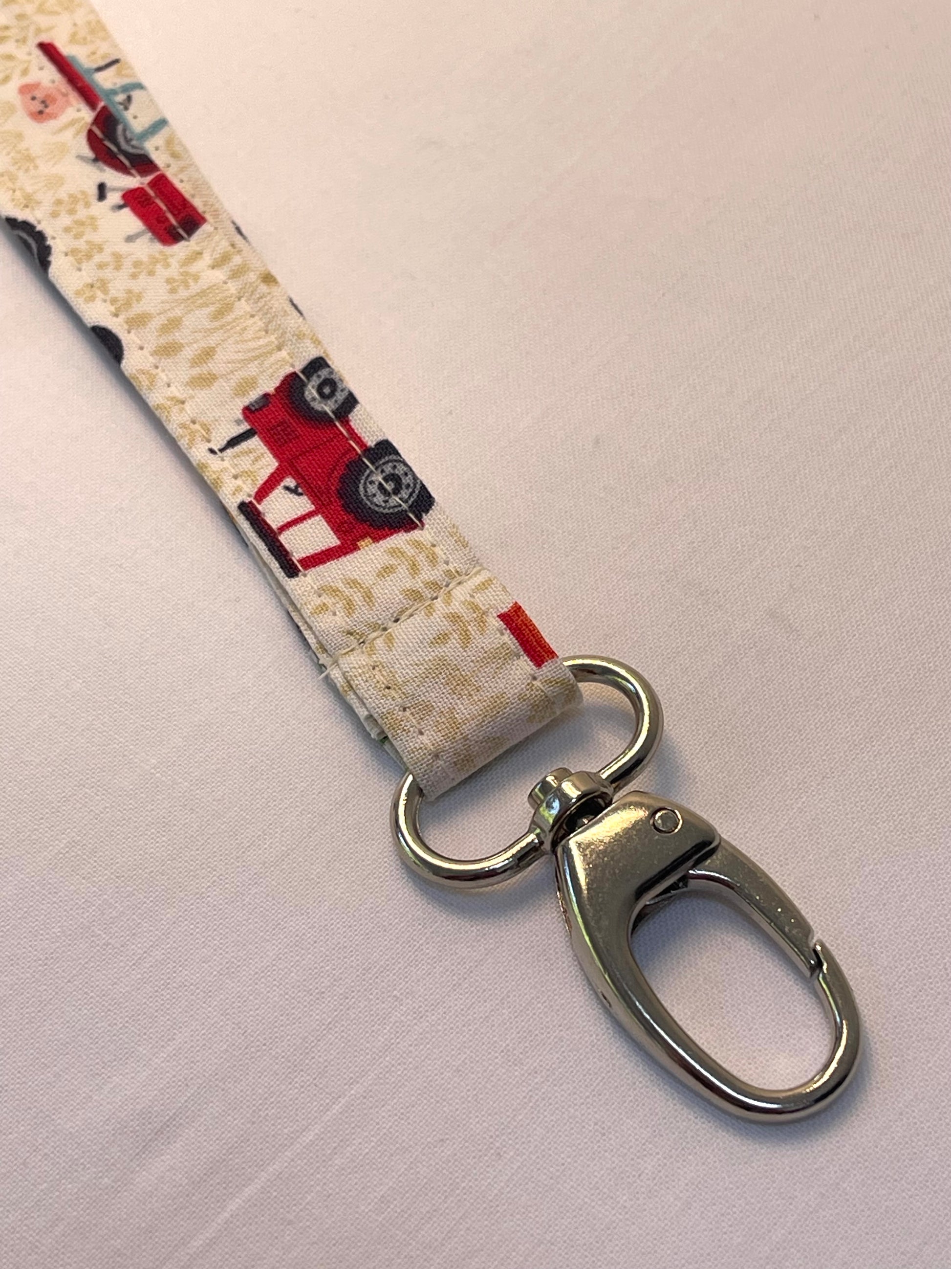 Fabric keychain with tractor pattern and metal clasp on a white background
