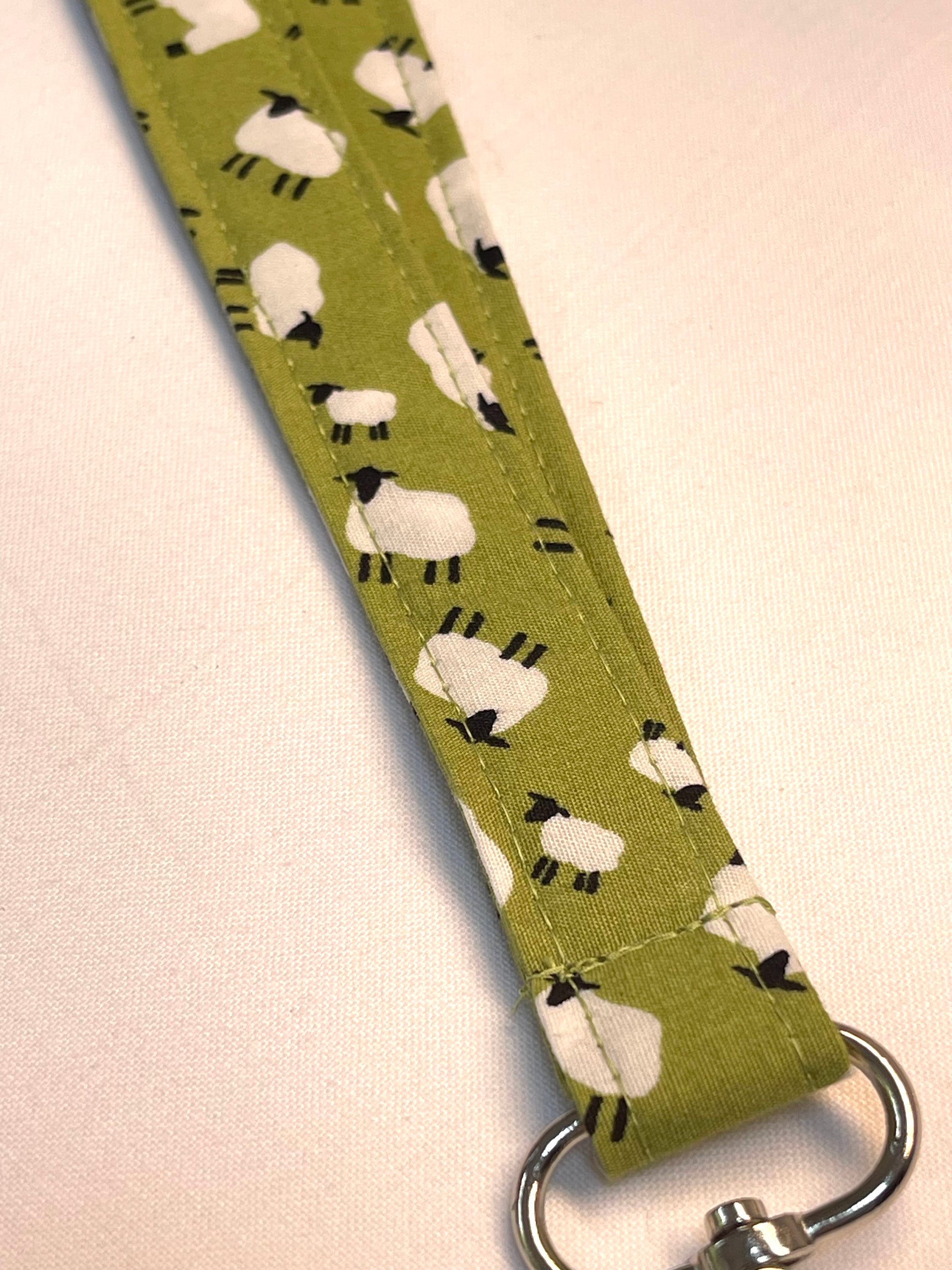 Fabric strap with sheep pattern on a green background
