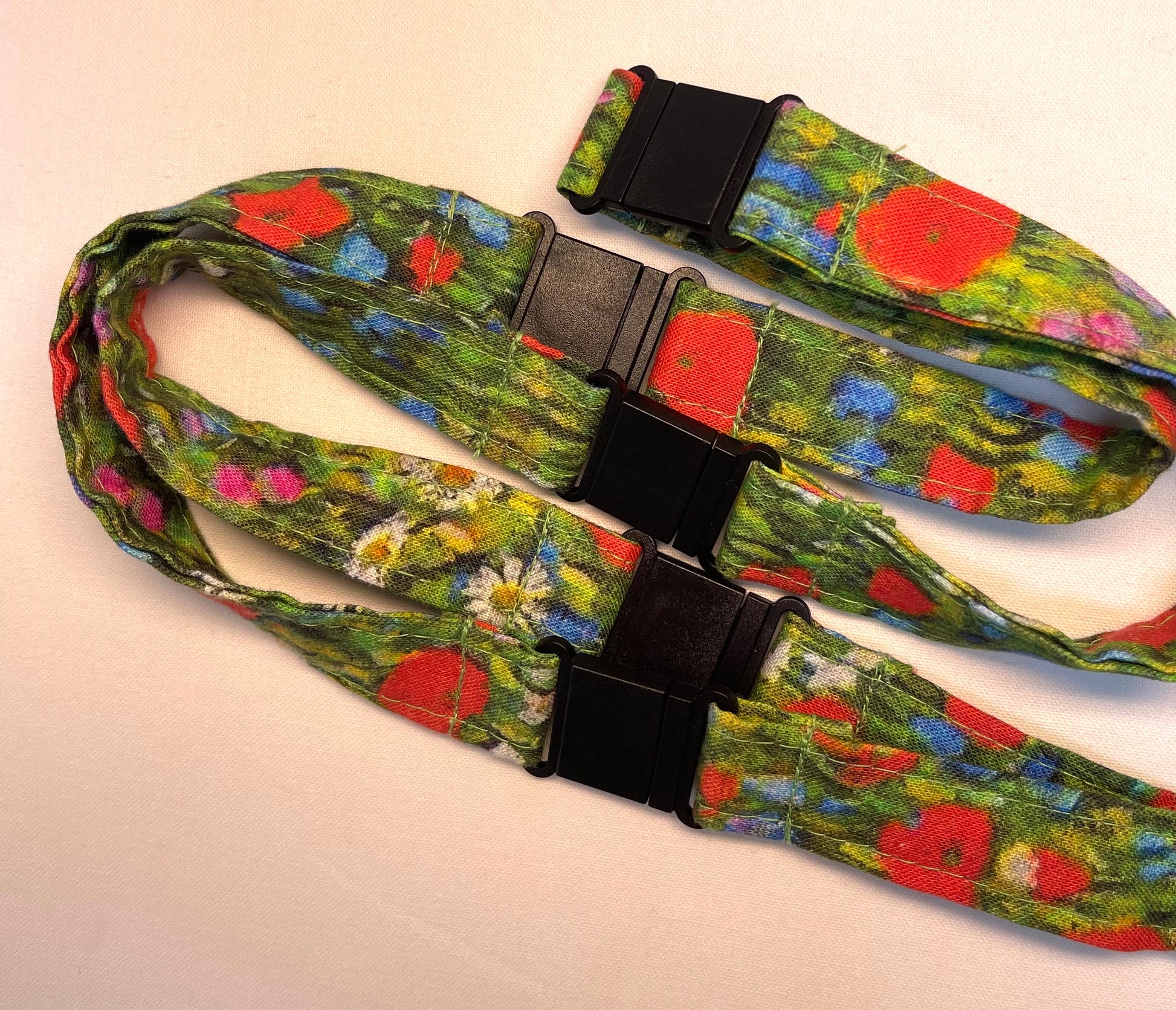 Floral-patterned lanyard with a black clip on a light background
