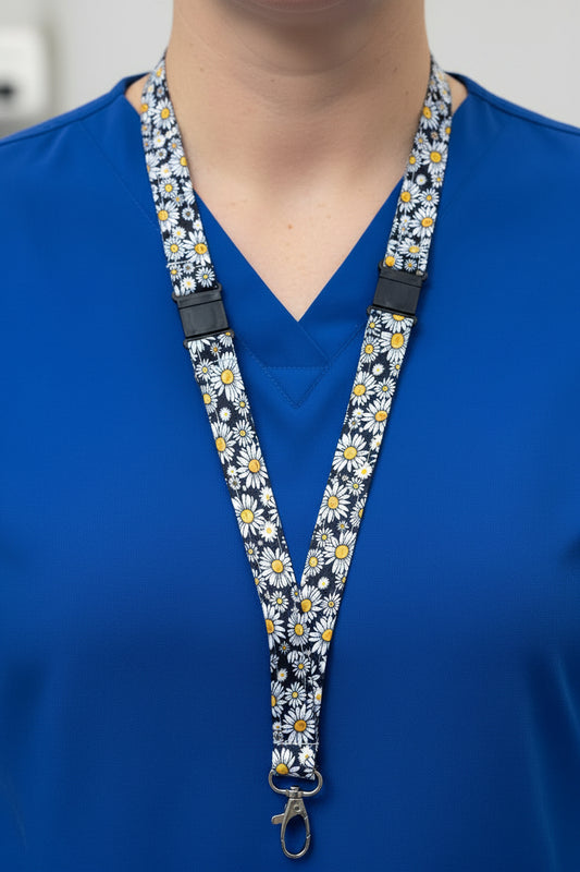 A fabric lanyard with a navy blue background and a white, yellow, and green daisy pattern, displayed on a light gray mannequin torso.