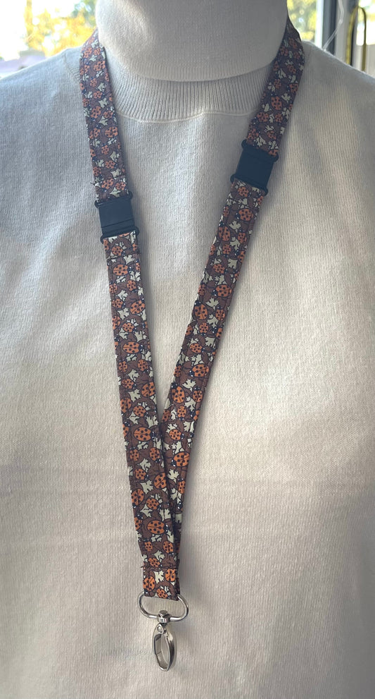 A lanyard featuring a pattern of ladybirds on leaves displayed on a mannequin.