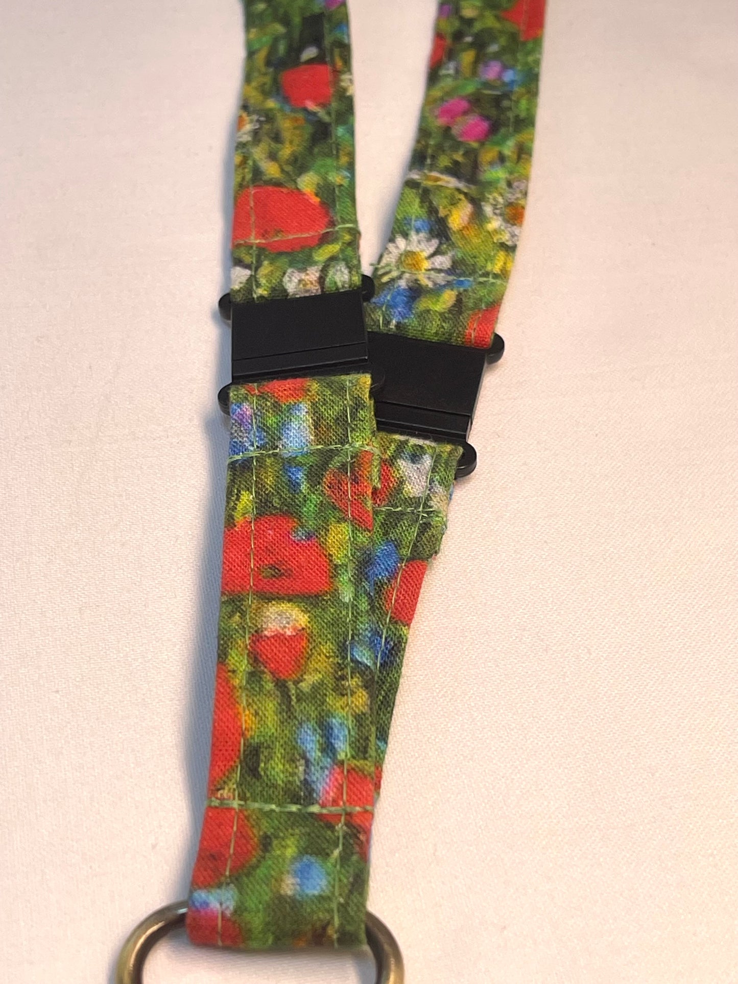 Floral patterned lanyard with a black breakaway clip on a white background