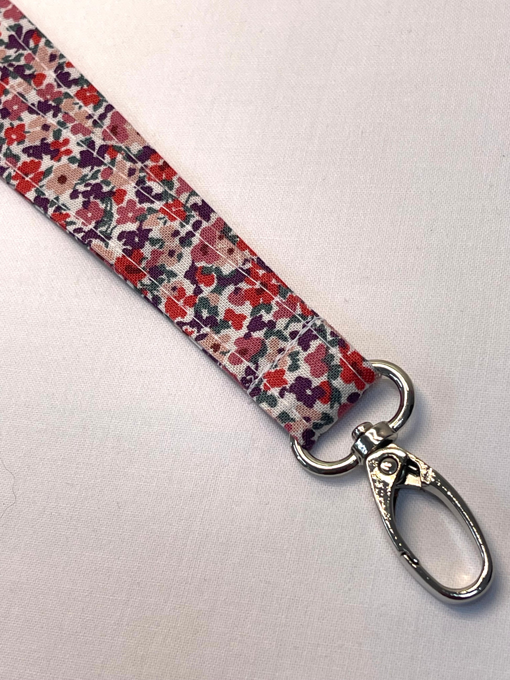 Floral patterned lanyard with a metal clasp on a white background