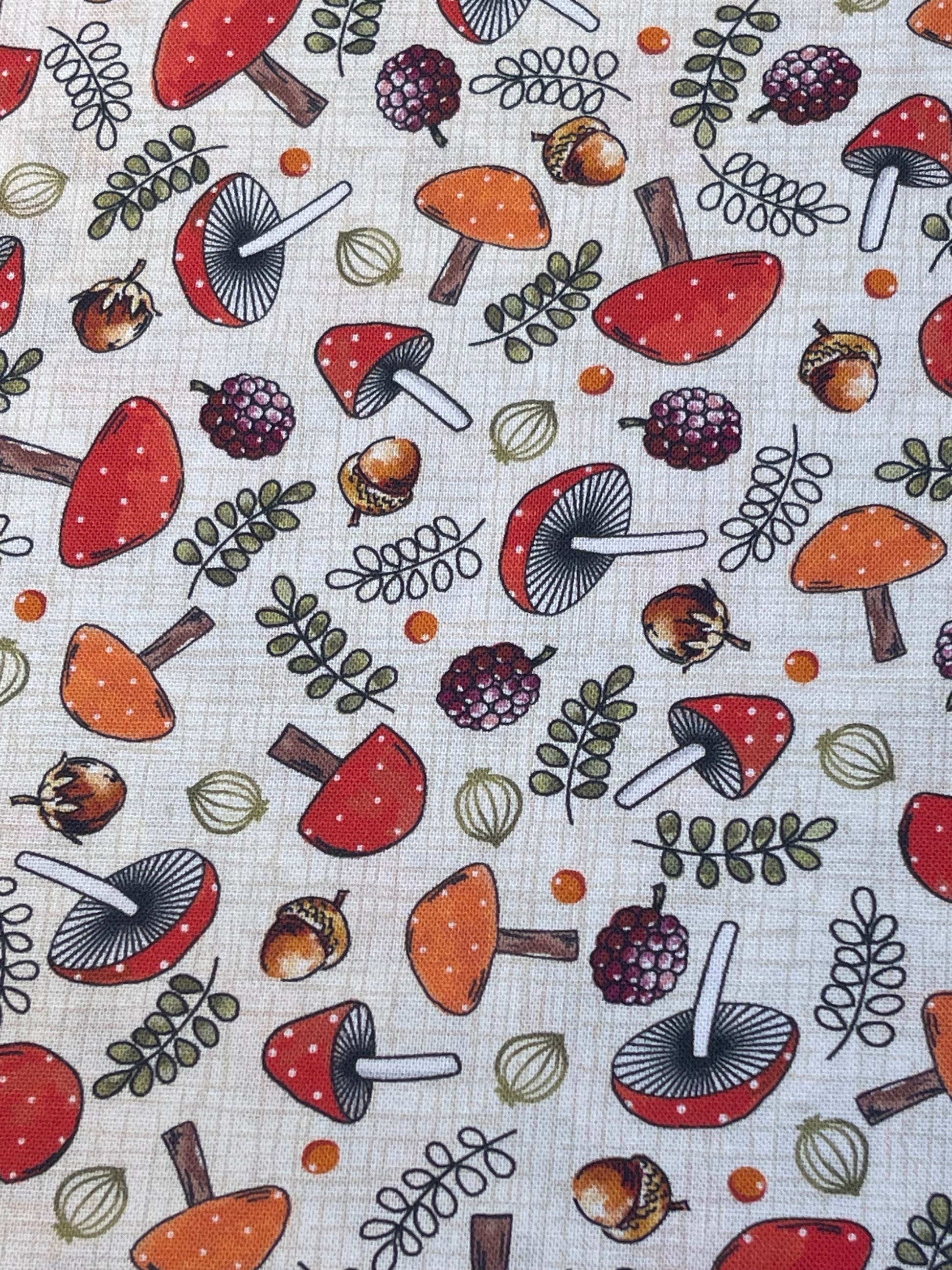 Pattern of mushrooms, berries, and leaves on a textured fabric background